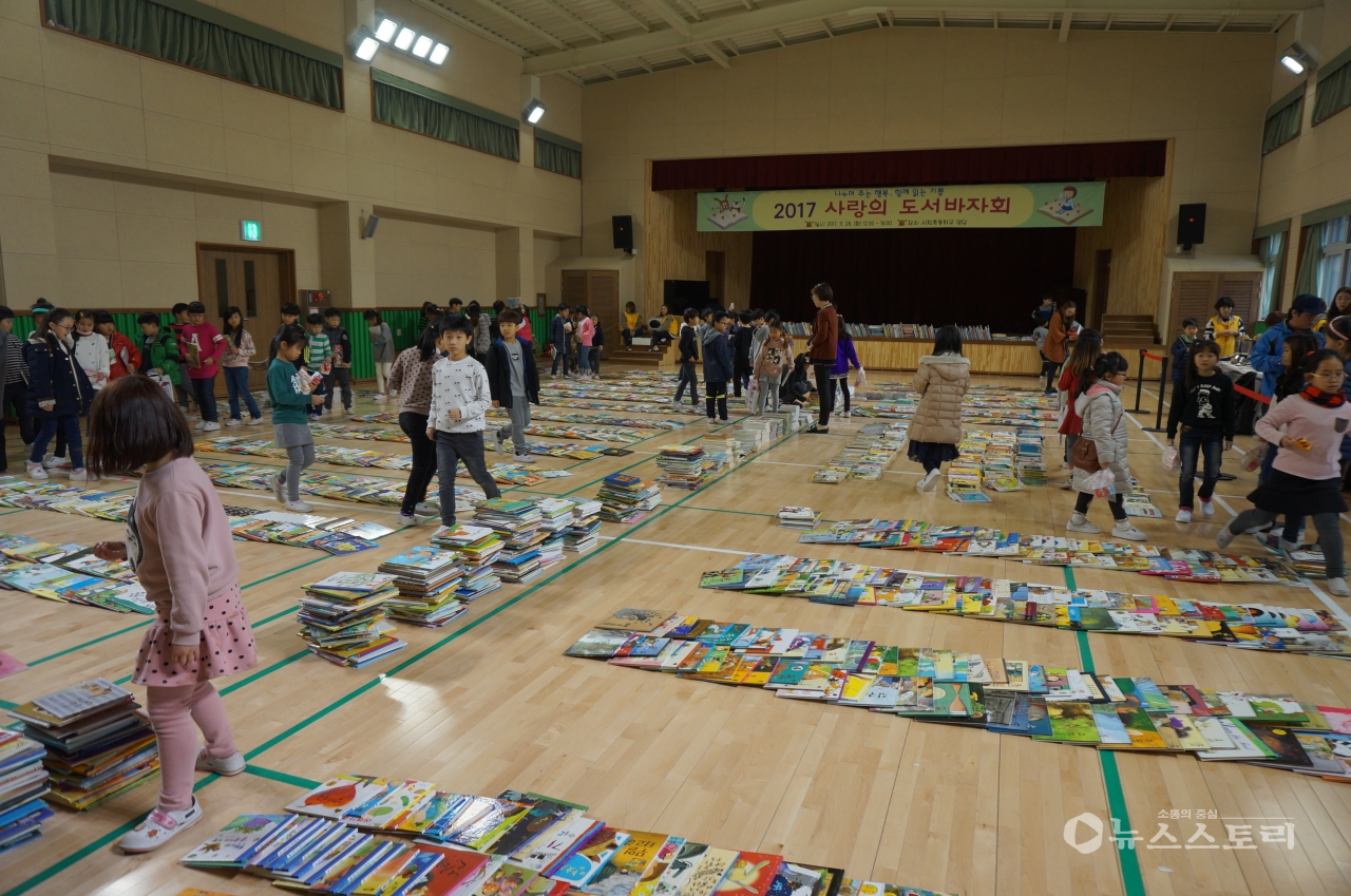 서천군 서천초등학교가 실시한 도서바자회에 학생들이 내놓은 도서 5,000여권이 쌓여 있는 가운데 학생들이 구입하고 싶은 책을 둘러보고 있다.
